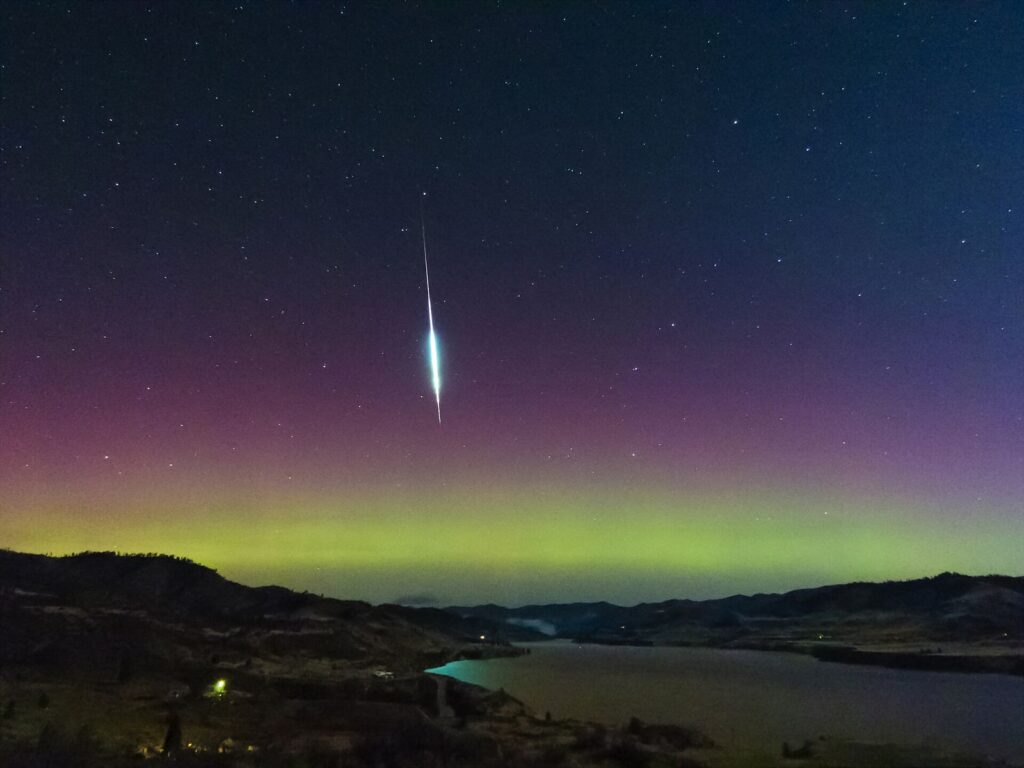 Un bolide des Taurides traversant le ciel nocturne au-dessus d’une aurore boréale