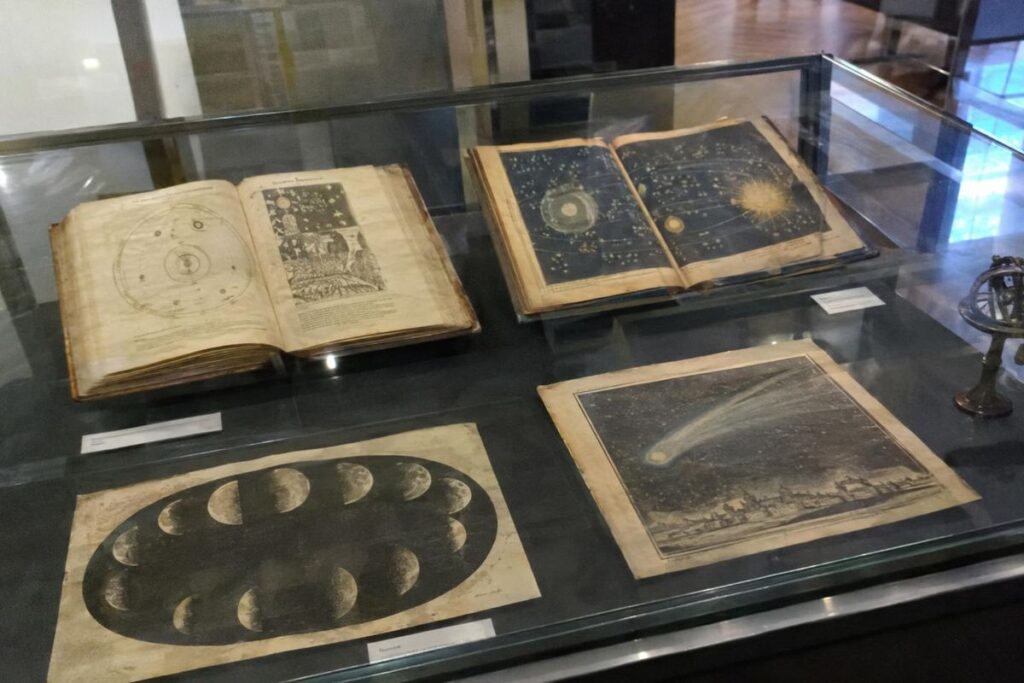 Livres anciens et gravures de phénomènes célestes dans une vitrine de musée