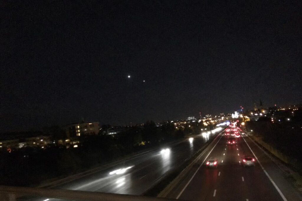 Illustration : deux points lumineux dans le ciel au-dessus d’une autoroute, de nuit