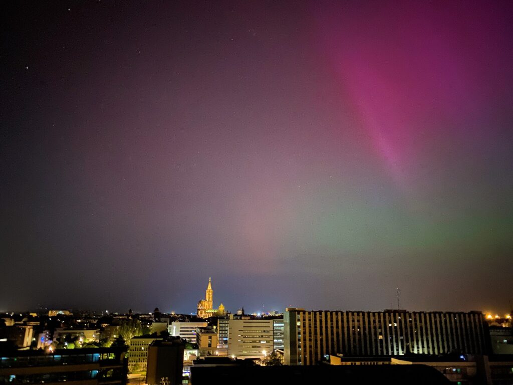 Aurore boréale rose et verte au-dessus de Strasbourg et de sa cathédrale, lors de la tempête géomagnétique de mai 2024
